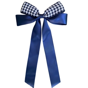 Elegant houndstooth and navy satin bow hairclip with long ribbons on white background