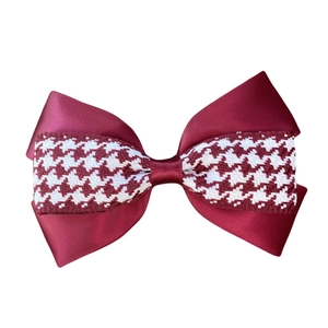 Close-up detail of double-layered burgundy satin hair bow with classic houndstooth pattern ribbon