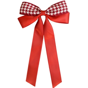 Detail of red houndstooth bow hair clip with satin ribbon and elegant long streamers