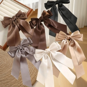 Vue détaillée de grandes barrettes à nœuds en satin aux tons marron et beige élégants