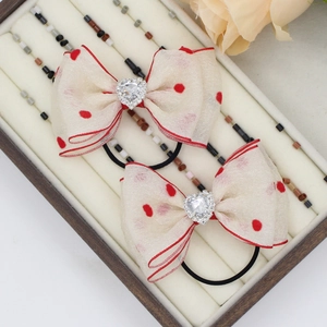 Pair of cream red polka dot chiffon bow hair ties with heart shaped crystal accents