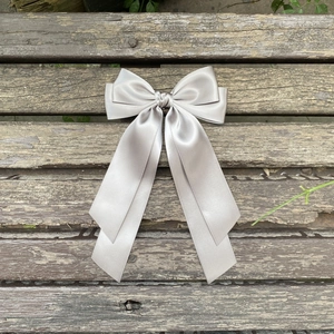 Vue détaillée de la pince à cheveux en satin gris argenté avec de longs rubans soyeux