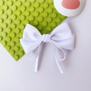 Elegant white satin ribbon bow hair clip with a smooth glossy finish for women