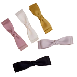 Détail de cinq pinces à cheveux à double nœud en satin dans des couleurs assorties