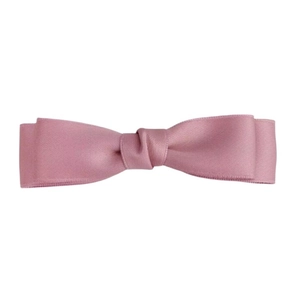 Détail d'une élégante pince à cheveux avec double nœud rose poudré en tissu texturé