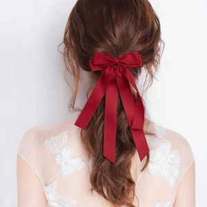 Pince à cheveux élégante en satin bordeaux avec longs rubans sur cheveux bruns