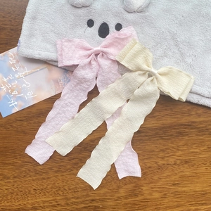 Detail of pink and cream pleated chiffon ribbon bow hair clips with long wavy streamers