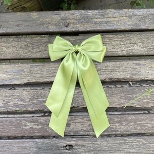 Détail d'un nœud papillon en satin vert clair à double épaisseur pour cheveux
