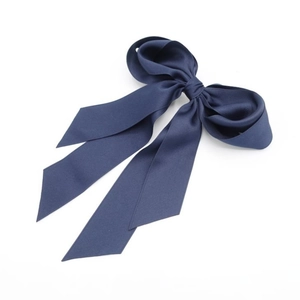 Dettaglio di un fiocco per capelli in raso blu navy con lunghi nastri eleganti
