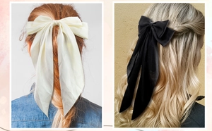 Macro detail of large satin hair bow clips with long ribbons in black and ivory colors