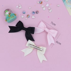 Three grosgrain ribbon bow hair clips in black, pink, and white with metal duckbill clips