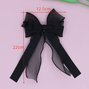 Barrette à cheveux avec nœud multicouche en organza noir et rubans sur fond rose