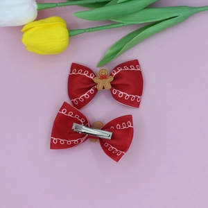 Pair of festive red ribbon bow hair clips with gingerbread man and metal alligator clip
