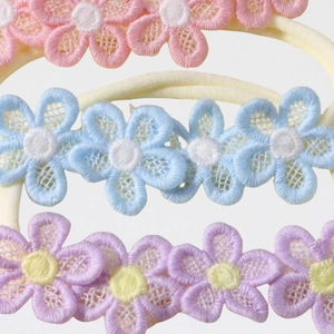 Three embroidered floral baby headbands in pink, blue, and purple with nylon bands