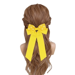 Fermaglio per capelli a fiocco giallo a pois con nastri lunghi su capelli mossi