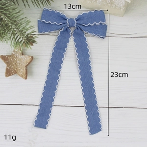 Barrette à cheveux nœud bleu denim avec bords ondulés blancs et longs rubans sur bois