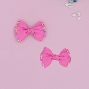 Close-up of pink grosgrain ribbon hair bows for children with colorful glitter sequin edges