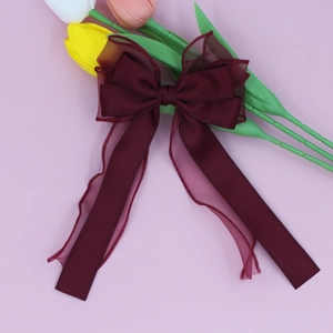 Vue détaillée de la barrette à nœud bordeaux double couche avec longs rubans en organza
