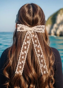 Detalle de pinza para el pelo con lazo de encaje beige y cintas largas estilo francés