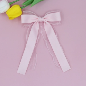 Détail du nœud rose à double couche en tulle avec longs rubans élégants et texture satinée