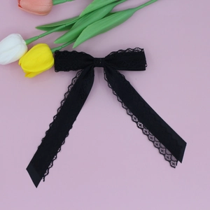 Detailed view of black layered lace hair bow with delicate scalloped floral edges