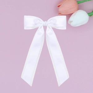 Detail of white double-layered satin ribbon bow hair clip with long elegant streamers
