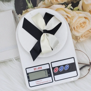 Glossy two-tone satin ribbon bow hair clip weighing 7g on a scale for women's hair accessory