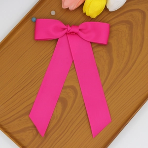 Détail de la pince à cheveux noeud en gros-grain rose fuchsia avec longs rubans