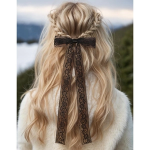 Elegant black embroidery lace bow hair clip with long ribbons on blonde braided hair