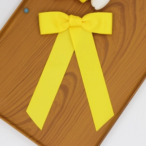 Détail du nœud en ruban gros-grain jaune vif avec de longs rubans élégants