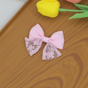 Sweet light pink lace bow hair clip with floral pattern on a rustic wooden tray