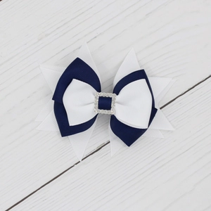 Dettaglio di un fiocco per capelli multistrato in gros-grain blu e bianco con fibbia