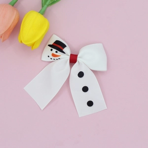 Détail d'une pince à cheveux nœud de bonhomme de neige de Noël sur fond rose doux