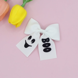 Barrette nœud Halloween blanche avec motif fantôme et texte BOO sur fond rose