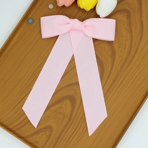 Détail de la pince à cheveux noeud en gros-grain rose avec de longs rubans élégants