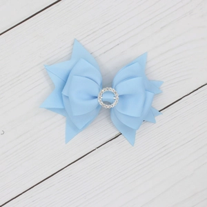 Dettaglio fiocco in gros-grain azzurro con decorazione centrale in strass argentati