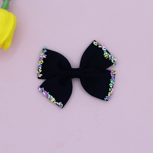 Detailed shot of black ribbed bow hair clip with colorful candy bead edges on pink background
