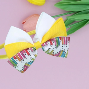 Colorful pencil print bow headband for kids with yellow and white ribbons on pink backdrop