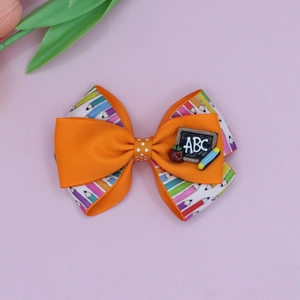 Detail view of double-layered back to school hair bow with pencil print and ABC resin decor