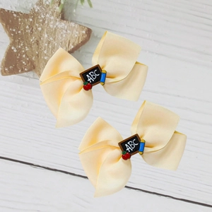 Paire de nœuds pour cheveux rentrée scolaire avec décor de tableau ABC et de pomme