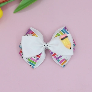 Detail of school bow hair clip with colorful pencil prints and white grosgrain ribbon
