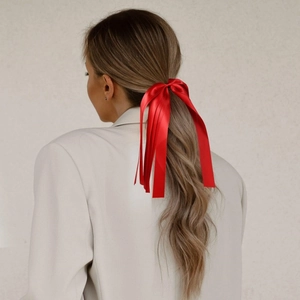 Détail d'un grand nœud de cheveux en satin rouge avec de longs rubans sur queue