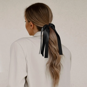 Élégant nœud de cheveux en satin noir avec de longs rubans vu de dos sur un mannequin