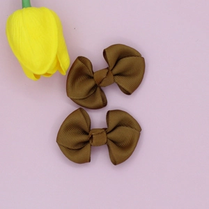 Detail of coffee brown ribbed grosgrain ribbon hair bow clips with textured fabric finish