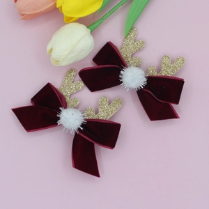Détail de pinces à cheveux de Noël avec nœuds en velours rouge et bois dorés pailletés