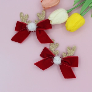 Détail de pinces à cheveux de Noël avec nœuds en velours rouge et paillettes dorées