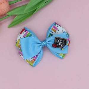 Detail of school bow clip with ABC blackboard and pencil prints on blue ribbon