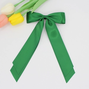 Détails macro du ruban de satin vert émeraude et des élégants longs rubans de nœud