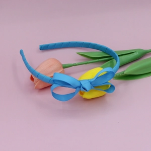 Sky blue grosgrain ribbon headband with matching bow, styled with pink tulip flowers