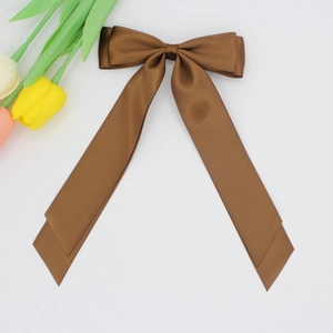 Gros plan d'un nœud papillon en satin marron avec une texture lisse et de longs pans
